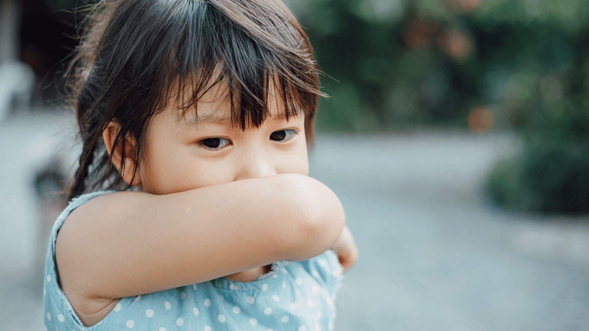 kid coughing or covering her nose