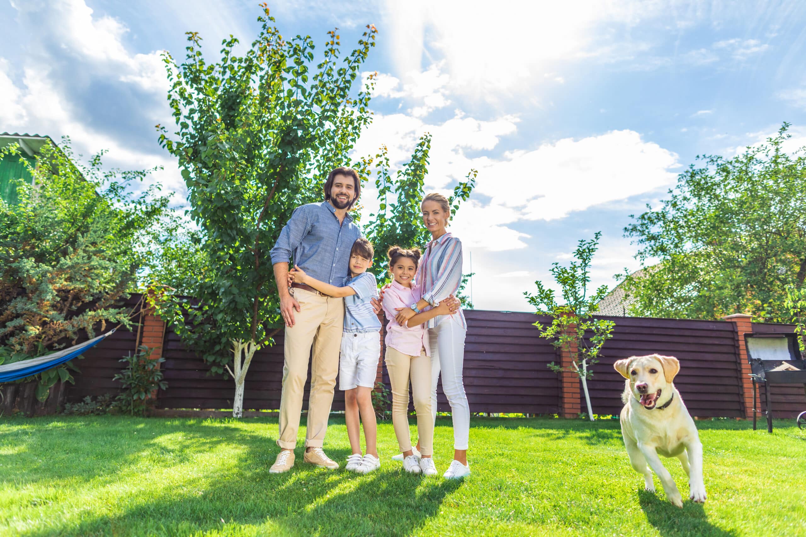 Technician checking shaded shrubs and fence lines near a small creek behind a Sterrett, Alabama home