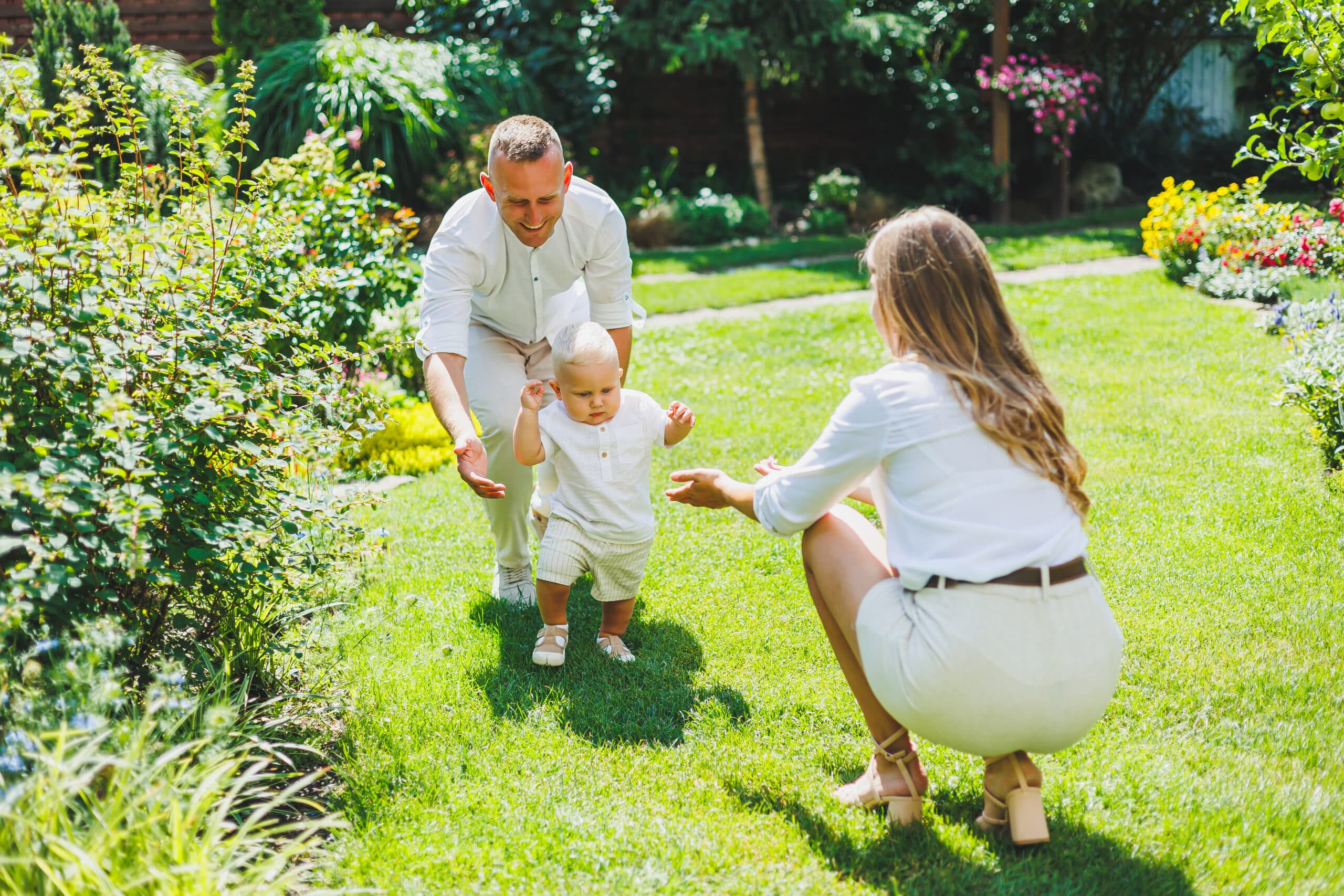 Technician inspecting shaded shrubs along a backyard fence beside a small creek branch in McCalla, Alabama